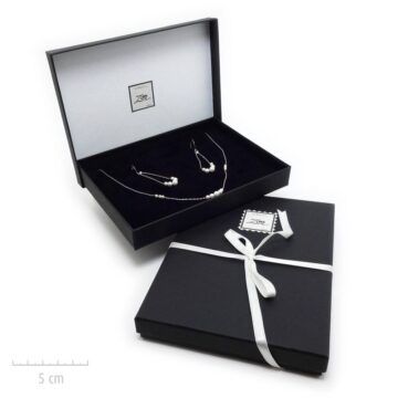 Un écrin noir habillé d'un ruban blanc. Emballage cadeau Vendôme de bijou Zor Paris. Broite, coffret, luxe.