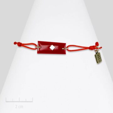 Bracelet lacet et drapeau rouge. Bijou rectangle à carreau, symbole du clan des Red Arlequin de TRH. Création Zor Paris